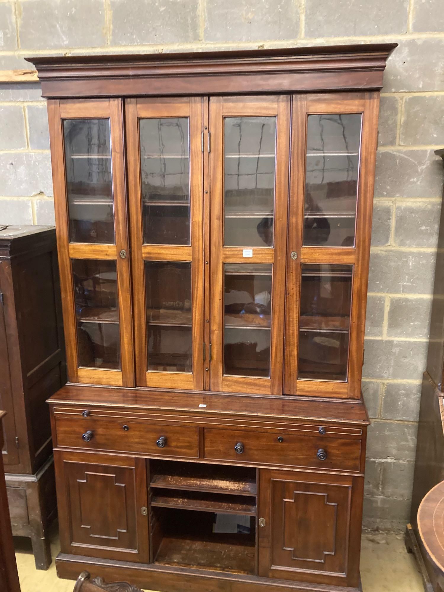 A Victorian mahogany bookcase cupboard, with pull out mid section writing slide, width 144cm depth 50cm height 245cm